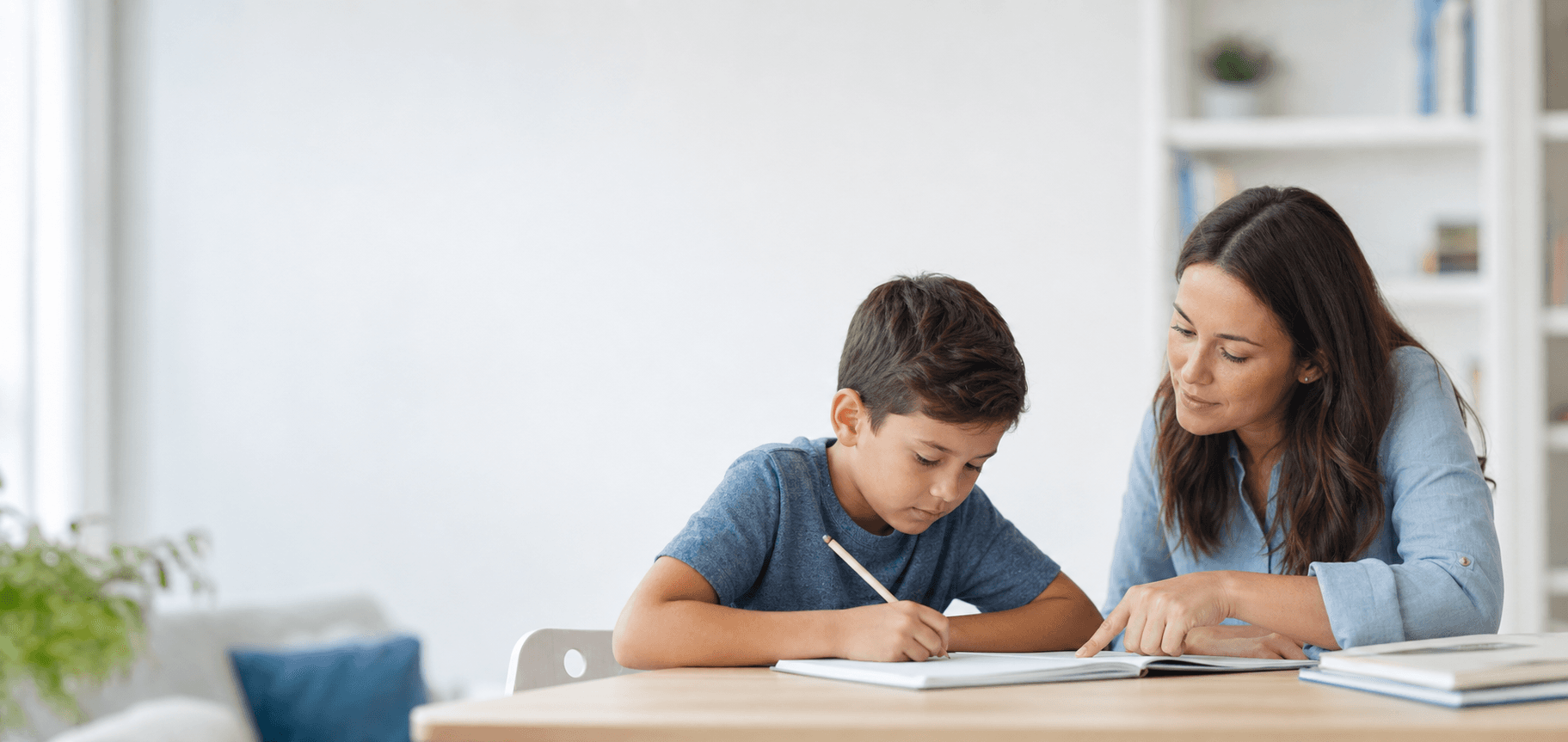 A tutor guiding a child as they write in a notebook
